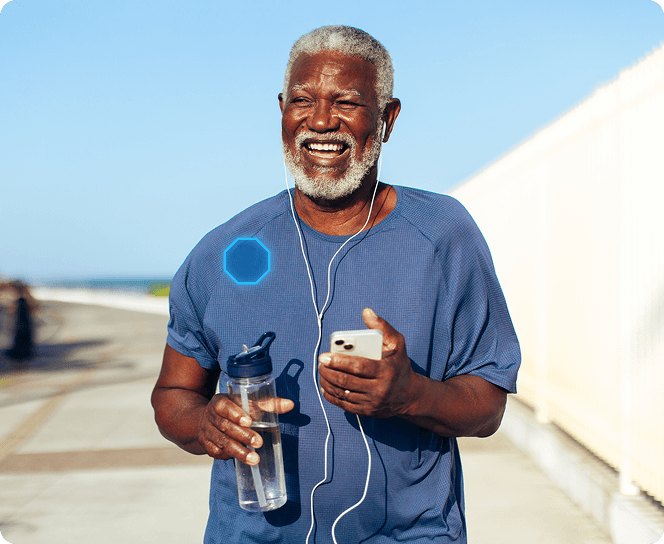 Senior man exercising outdoors with his smartphone and water bottle in hand. There is a glowing ADT emblem on his right shoulder, indicating the new My Safety service in the ADT+ app.